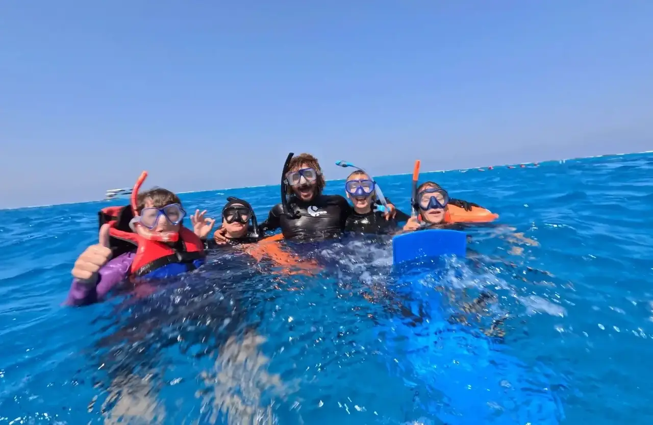 Smiling group of snorkelers in life vests at the surface