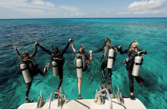 Divers jumping together from a boat into the Red Sea