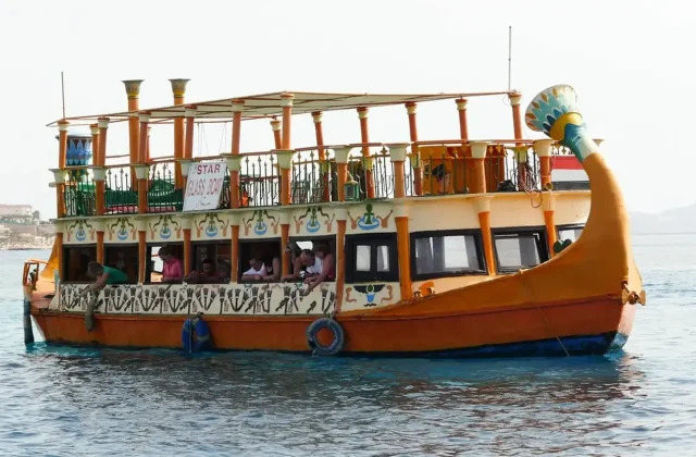 Buntes hölzernes Glasbodenboot auf ruhigem blauem Wasser