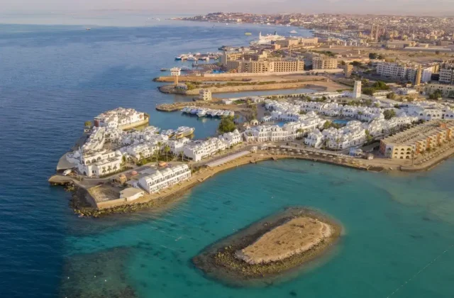 Aerial view over the Hurghada coastline, a small harbour and turquoise reef water