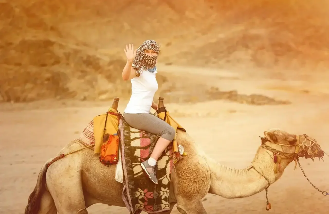 Woman smiling while sitting on a camel