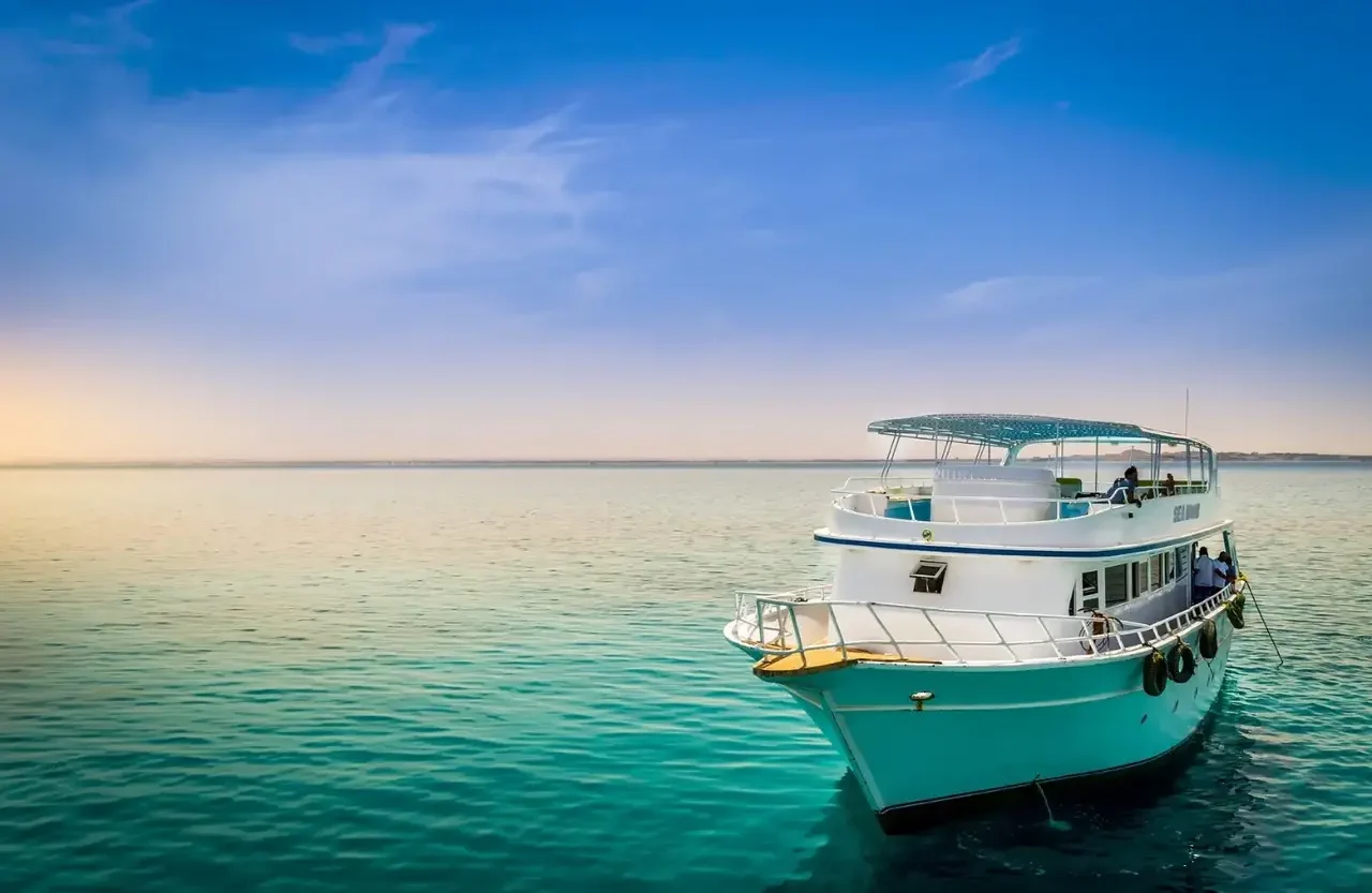 White excursion boat on a calm sea in soft morning light