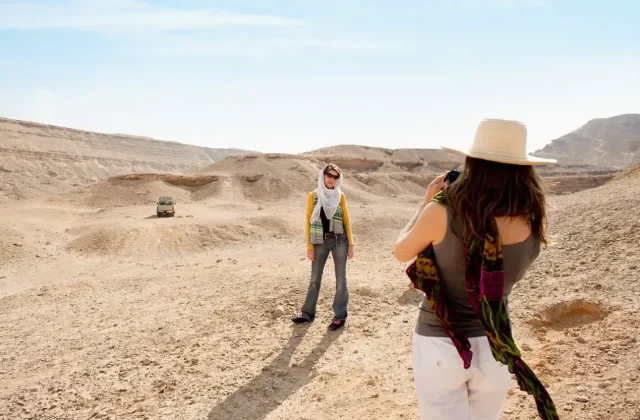 Two women in the back of a safari jeep in the desert