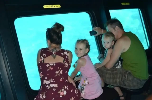 Family looking at the reef through the windows of a semi-submarine cabin
