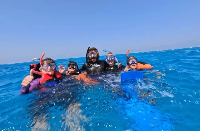 Smiling group of snorkelers in life vests at the surface