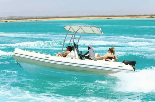Guests on a speedboat cruising over turquoise water